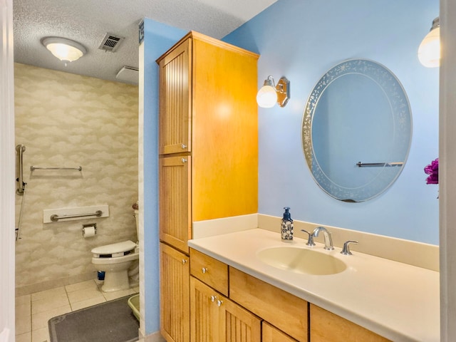 bathroom featuring tile patterned flooring, vanity, a textured ceiling, and toilet