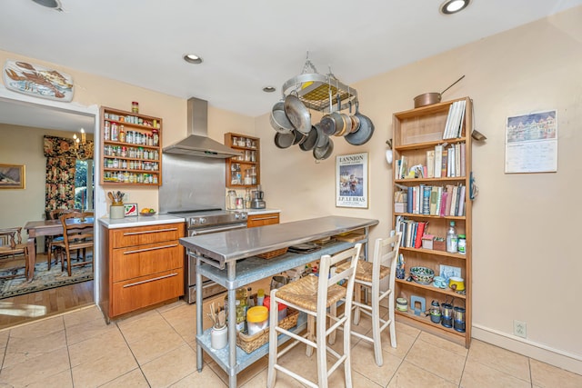 kitchen featuring stainless steel range with electric cooktop, light tile patterned flooring, and wall chimney range hood