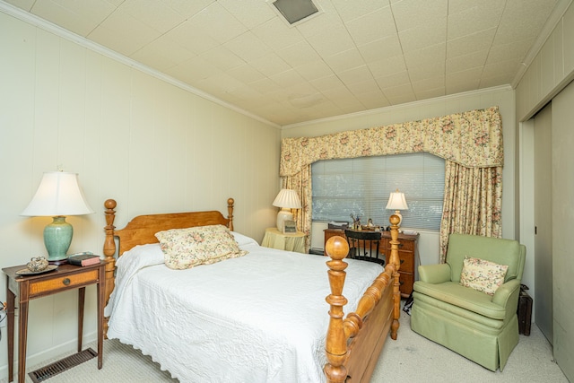 bedroom featuring light colored carpet, crown molding, and a closet