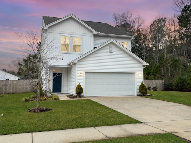 view of property with a garage and a lawn