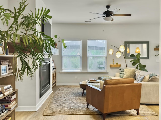 living room with light hardwood / wood-style floors and ceiling fan