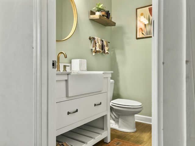 bathroom featuring vanity, wood-type flooring, and toilet