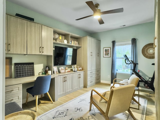 office featuring ceiling fan, built in desk, and light wood-type flooring