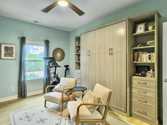 living area with ceiling fan and light wood-type flooring