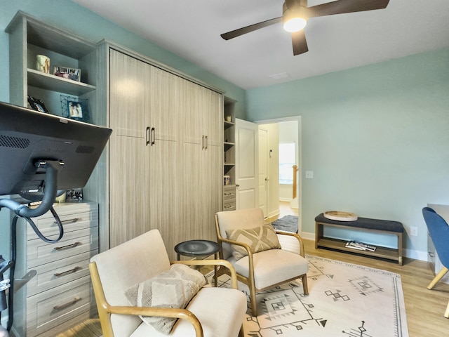 sitting room with ceiling fan and light wood-type flooring