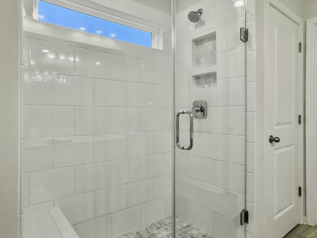 bathroom featuring a shower with shower door