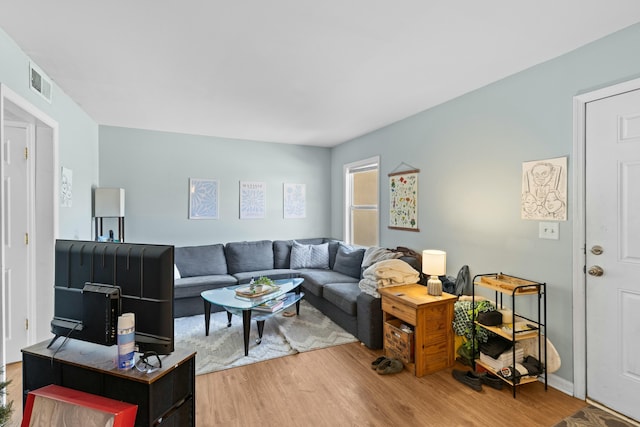 living area featuring visible vents and wood finished floors