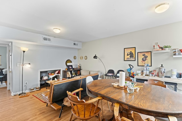 dining space featuring light wood-style floors and visible vents