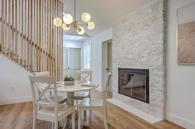 2534 Flamingo Dr, Charleston, SC 29414 - dining room featuring a stone fireplace, wood finished floors, baseboards, and a chandelier