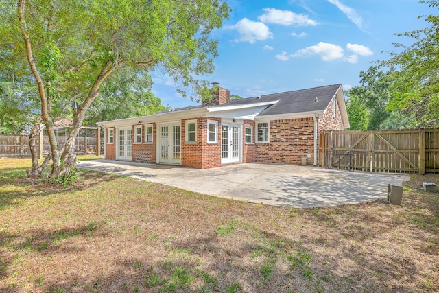 2534 Flamingo Dr, Charleston, SC 29414 - rear view of house with french doors, brick siding, a chimney, a patio area, and a fenced backyard