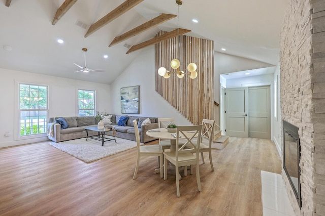 2534 Flamingo Dr, Charleston, SC 29414 - dining room with light wood-style floors, beamed ceiling, high vaulted ceiling, a chandelier, and a stone fireplace