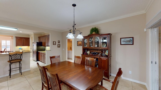 dining room featuring light tile patterned floors, a chandelier, and crown molding