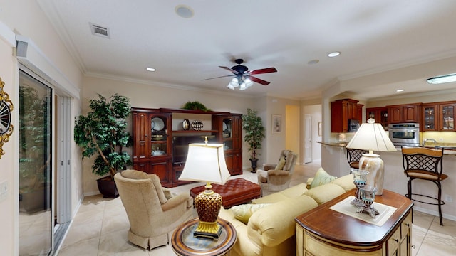 living area featuring ceiling fan, recessed lighting, light tile patterned floors, and ornamental molding
