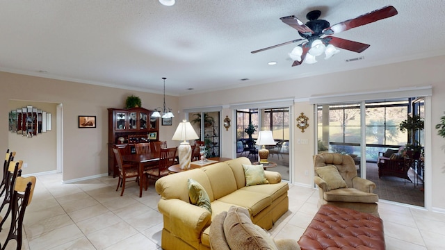 living room featuring ceiling fan, light tile patterned flooring, ornamental molding, and a chandelier