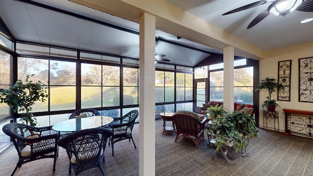 sunroom / solarium with ceiling fan, a wall of windows, carpet, and outdoor dining space