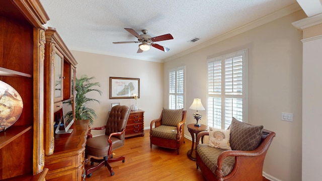 home office with ceiling fan, light wood-style floors, a textured ceiling, and crown molding