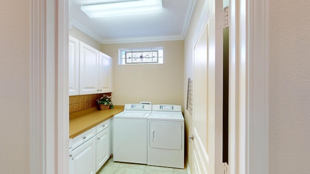 laundry area featuring cabinet space, crown molding, washing machine and dryer, and light tile patterned flooring