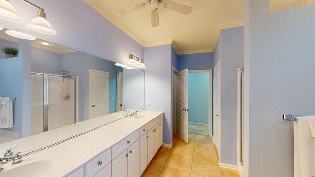 bathroom with a shower stall, double vanity, ceiling fan, crown molding, and tile patterned floors