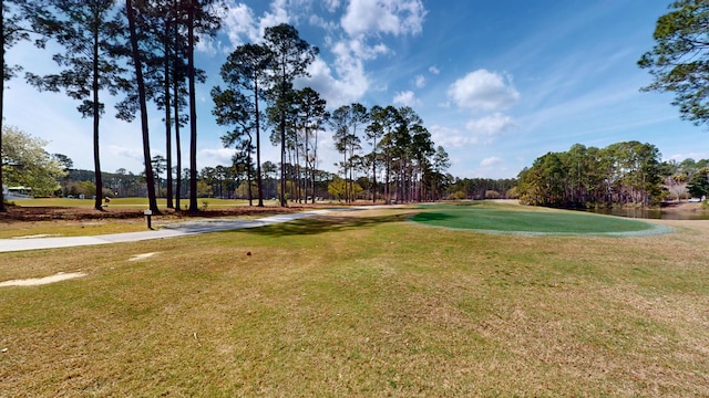 view of home's community featuring a lawn and view of golf course