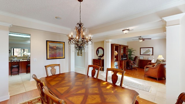 dining area featuring crown molding, ceiling fan, light wood finished floors, a chandelier, and a textured ceiling