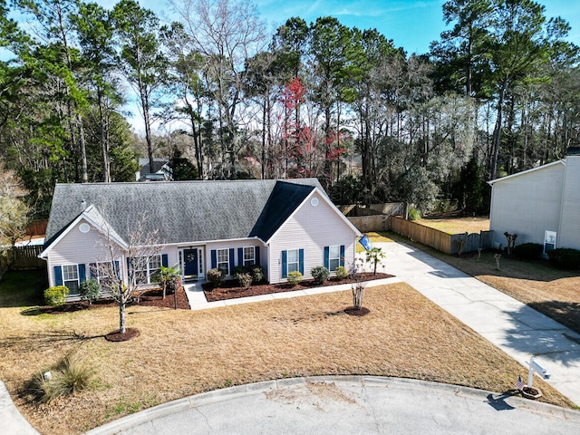 view of front of property with a shingled roof, fence, and driveway