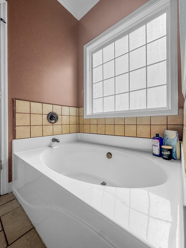 bathroom with a bath and crown molding