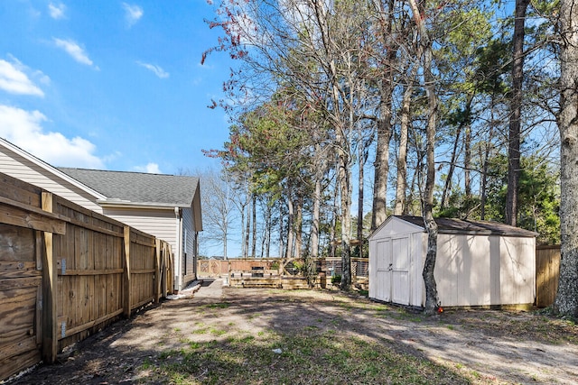 view of yard with a shed, fence, and an outbuilding