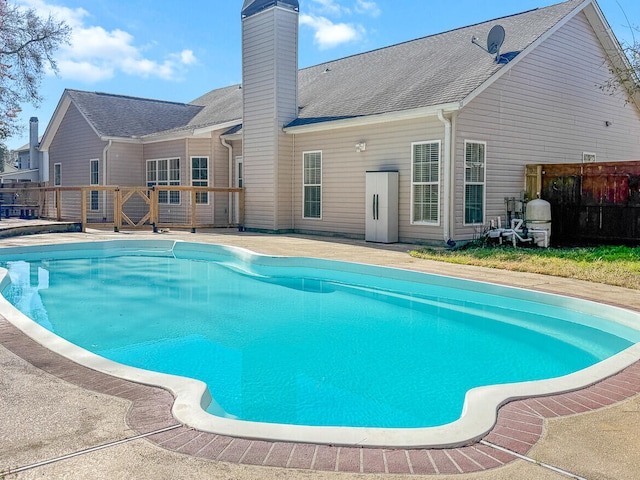 outdoor pool featuring a patio area and fence