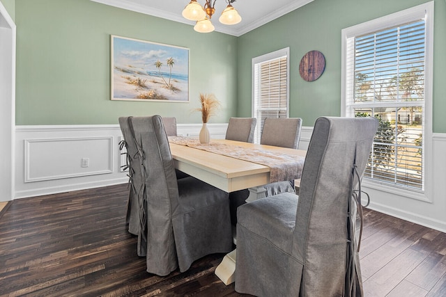 dining space with wainscoting, a chandelier, dark wood-type flooring, and ornamental molding