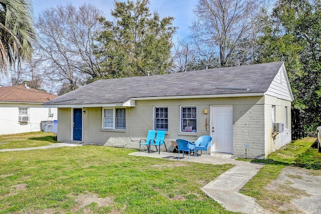 back of house with a yard, cooling unit, a patio, and roof with shingles