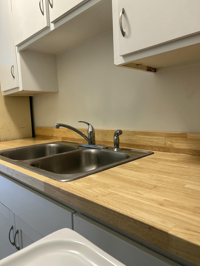 kitchen featuring white cabinetry and a sink