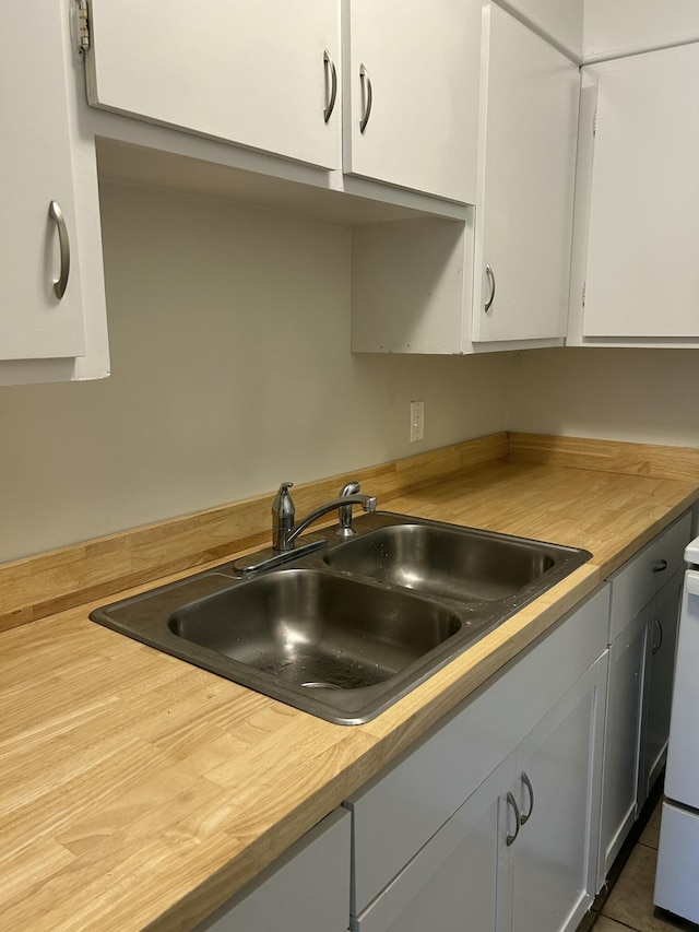 kitchen featuring white cabinetry and a sink