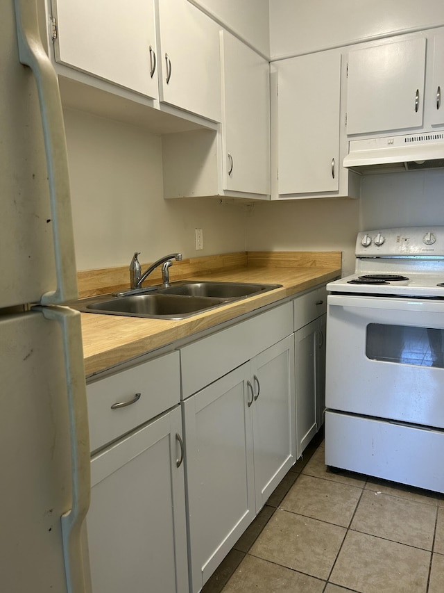 kitchen with light tile patterned floors, a sink, white cabinetry, white appliances, and under cabinet range hood
