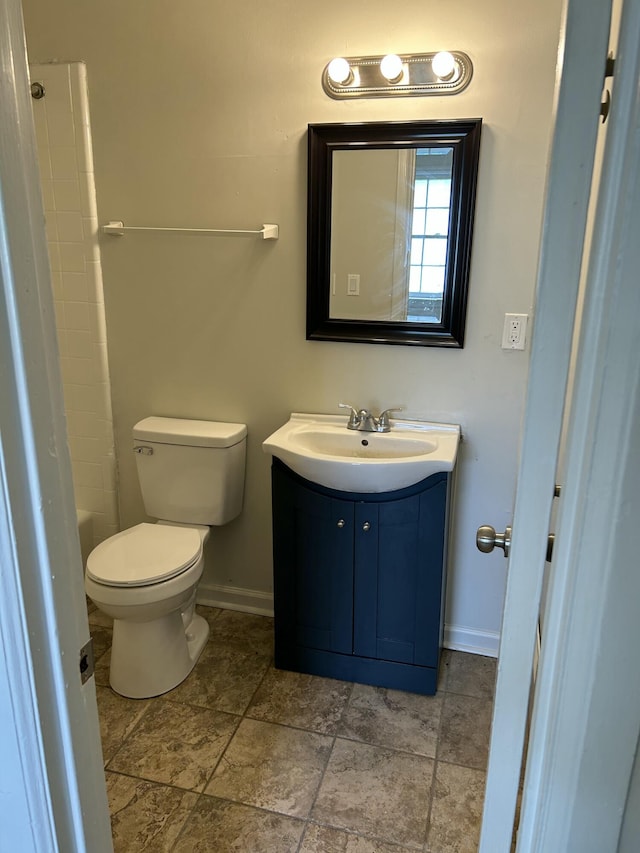 bathroom with toilet, baseboards, and vanity