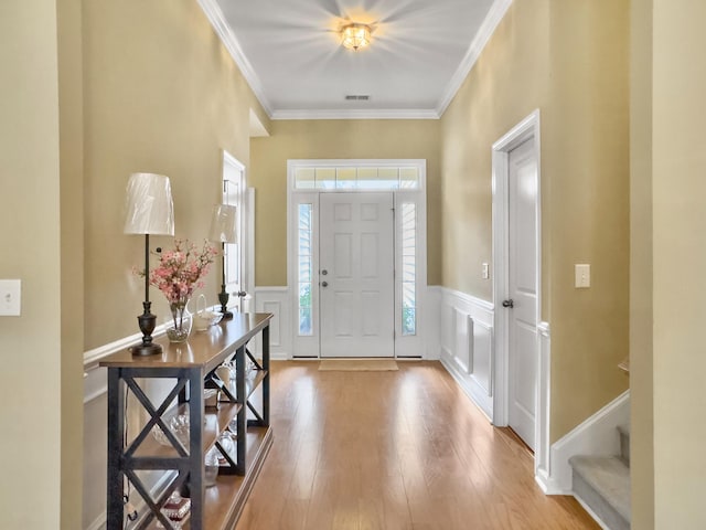 foyer with light wood-type flooring and ornamental molding