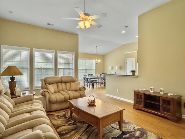 living room with ceiling fan with notable chandelier, light wood-type flooring, and lofted ceiling