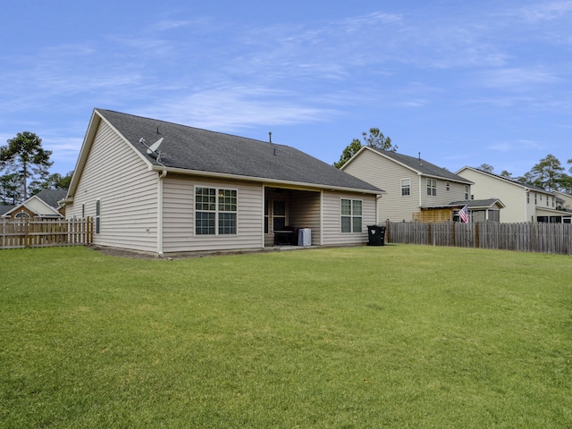 back of property with cooling unit and a lawn