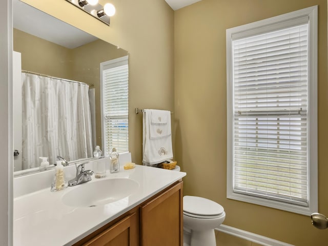 bathroom with vanity, a healthy amount of sunlight, and toilet