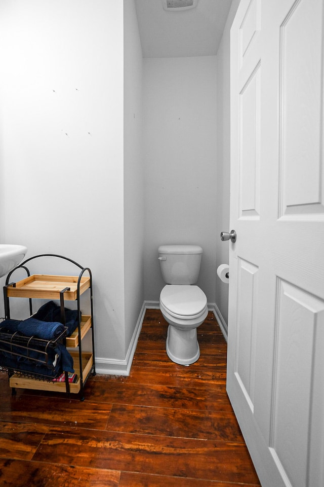 bathroom with wood-type flooring and toilet