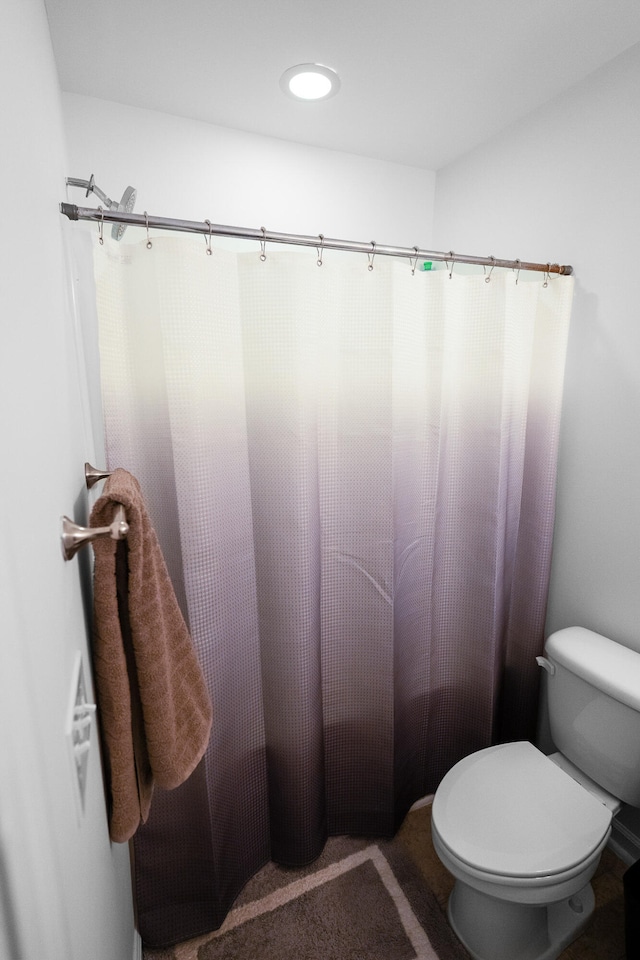 bathroom with a shower with shower curtain and toilet