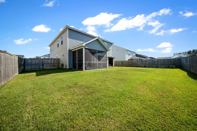 rear view of property with a yard and a sunroom