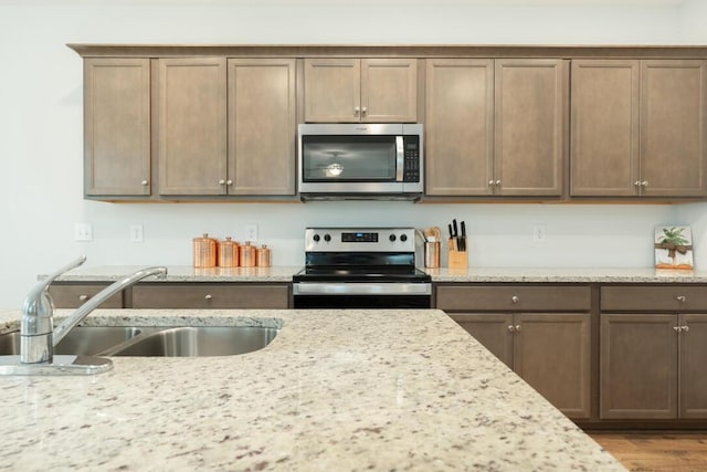 297 Red Leaf Blvd, Moncks Corner, SC 29461 - kitchen with appliances with stainless steel finishes, a sink, light stone countertops, and wood finished floors
