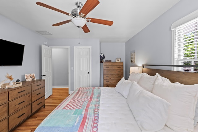 bedroom featuring visible vents, a ceiling fan, and light wood-style floors