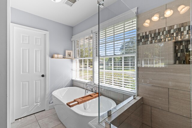 bathroom with a soaking tub, tile patterned flooring, and visible vents