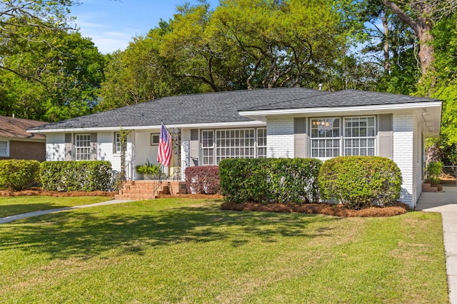 ranch-style house featuring a front yard and brick siding
