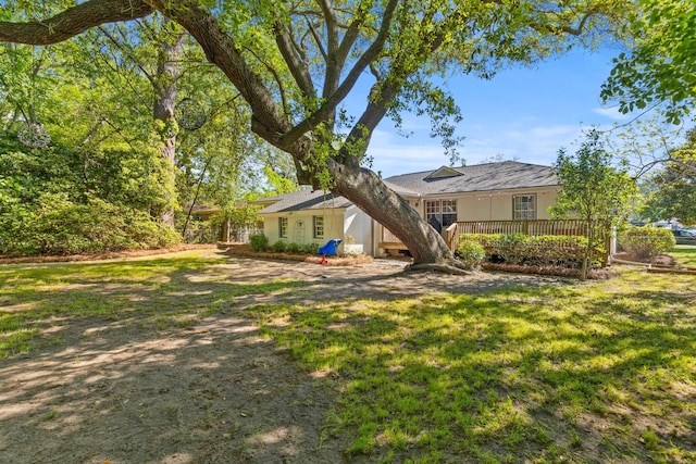 exterior space with a wooden deck and a front lawn