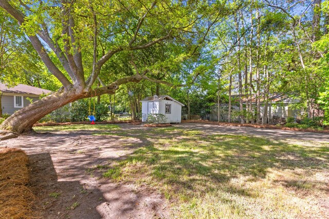 view of yard with a storage shed, an outbuilding, and fence