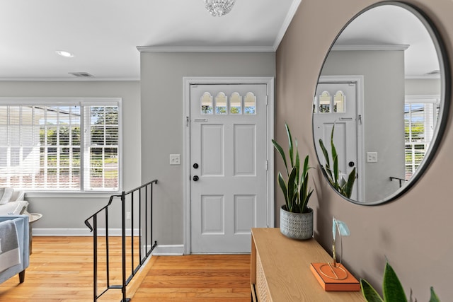 entrance foyer with plenty of natural light, visible vents, crown molding, and light wood-style flooring