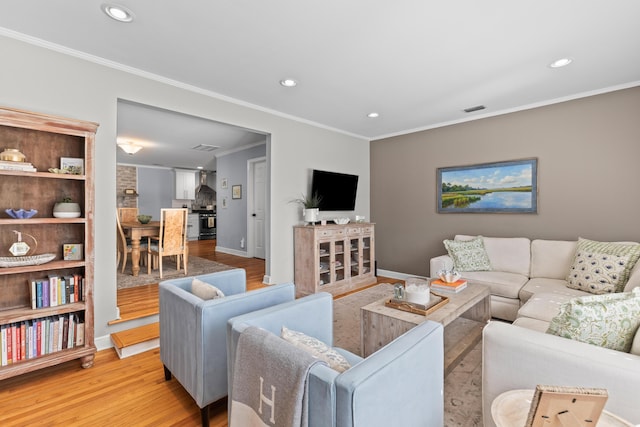 living area featuring recessed lighting, light wood-style floors, and crown molding