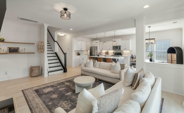 living room featuring an inviting chandelier and light hardwood / wood-style flooring